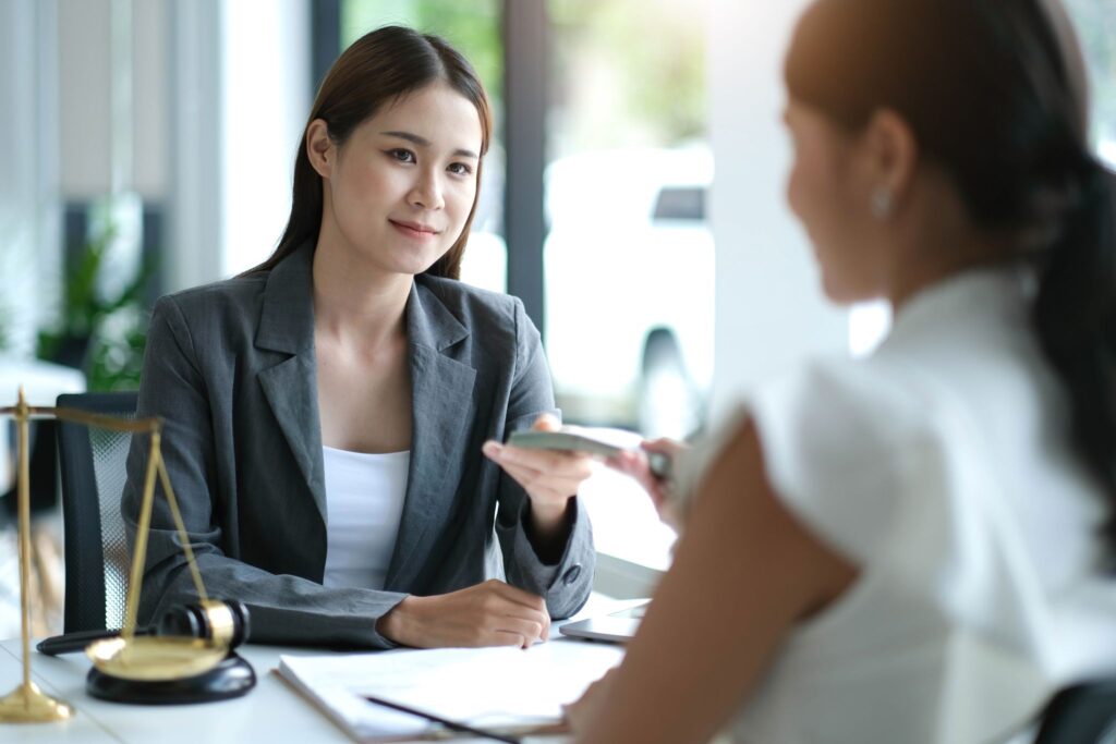 a person sitting at a table with a gavel and a person holding a remote