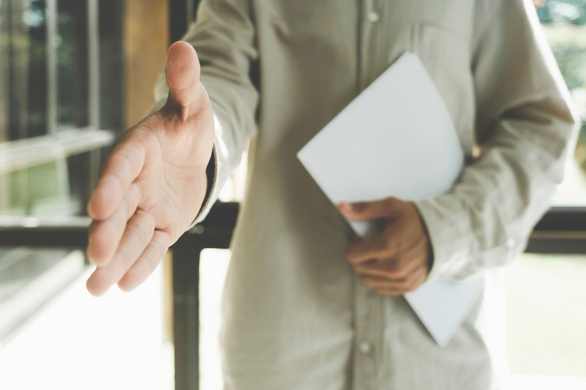 Businessman hand reaching out offering handshake. Close up agent reach out hand to camera handshake client.